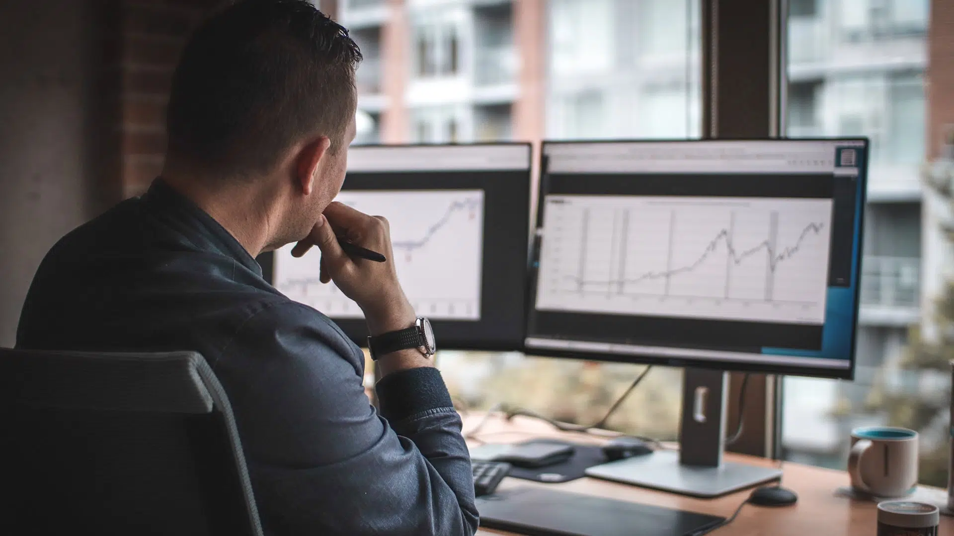 manager using 2 screens to analyze data