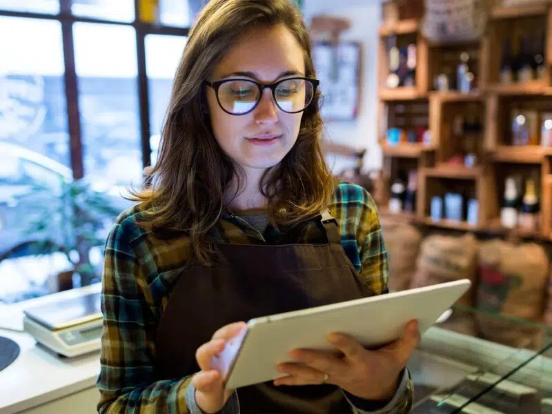 store owner doing inventory management on tablet